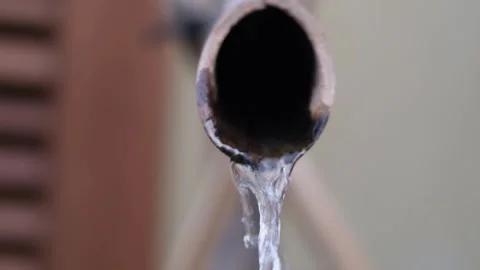 Extreme close up of water dripping from a pipe conceptualizing drought and water Видео 340665827