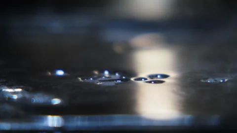 Extreme close up water falling on a hot griddle and evaporating 4K Stock Footage 246556050