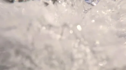 Extreme close-up of water falling from waterfall splashing in river cascades Stock Footage 303336889