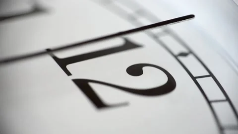 Extreme close up of a white clock ticking. Focus on number 12. 60fps Stock Footage 139594345