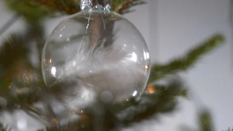 Extreme close up, white feather inside transparent Christmas bauble, Stock Footage 122938385