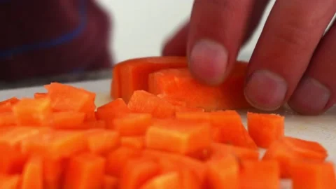 Extreme close up of a white man's hands cutting a carrot into small squares with Video stock 181774403