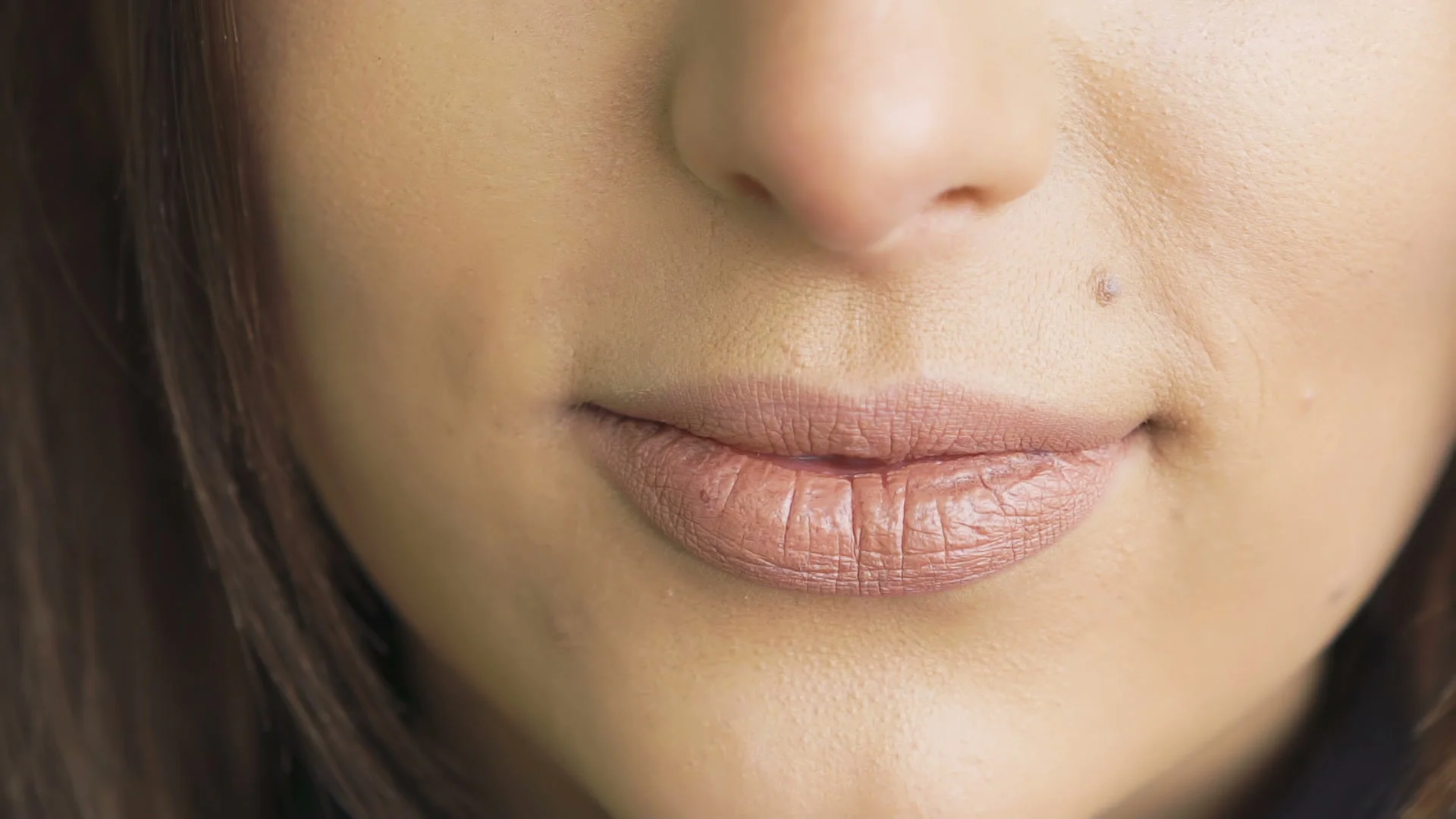 Extreme close up of woman licking and bitting lips. Slowly