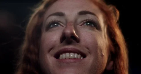 Extreme close up of a woman's smiling face as she enjoys a movie Stock Footage