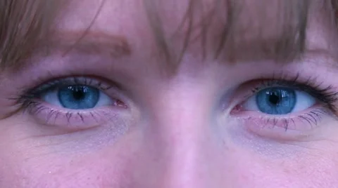 Extreme close-up young female opens blue eyes Stock Footage 52801193