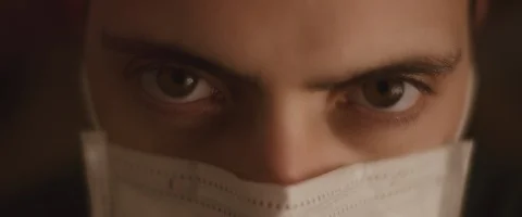 Extreme close up of a young man opening his eyes while wearing a mask Stock Footage 126341838
