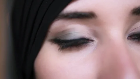 Extreme close-up of a young middle eastern muslim woman in black hijab opening Stock Footage 108782017