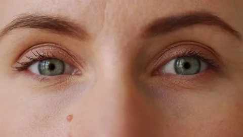 Extreme close-up of young woman opens her eyes and look at camera and open 库存影片 188921353