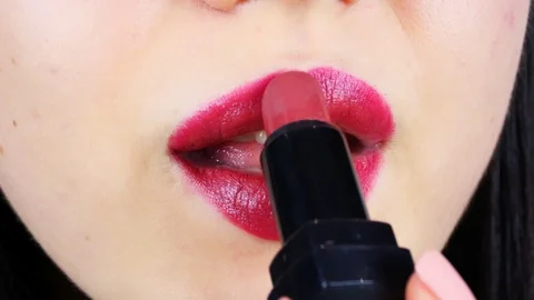 Extreme close-up of young woman's lips. Woman paints her lips with red lipstick. Stock-Footage 112956504