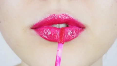 Extreme close-up of young woman's lips. Woman paints her lips with red lipstick. Stock Footage 112957258