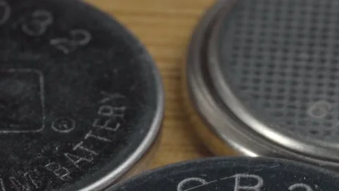 Extreme Closeup of Button Cell Batteries Showing Engraved Model Numbers and Stock Footage 340807637
