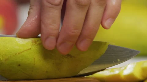 Extreme closeup of delicious mango being sliced and squared in slow motion Stock Footage 341262868