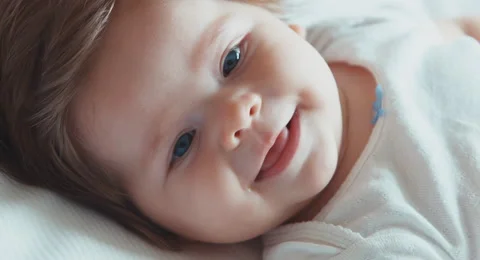 Extreme closeup face of a happy newborn baby girl boy. Smiling at camera. Top Stock Footage