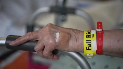 Extreme closeup of Fall Risk wristband on elderly patient in hospital as she 스톡 동영상 286344705