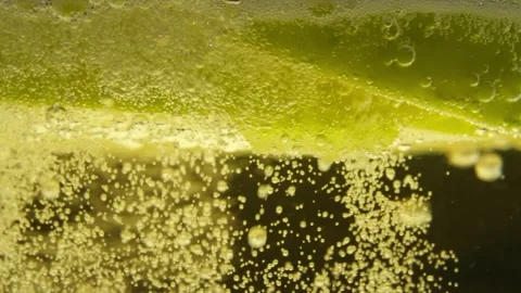 Extreme Closeup of Fizzy Cider Surface With Apple Slice and Rising Bubbles Video stock 305461785
