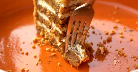 Extreme closeup of fork picking up carrot cake bite beside creamy layers Stock-Footage 343421917