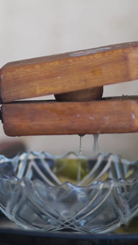 Extreme Closeup Of Lemon Being Squeezed With Traditional Wooden Lemon Squeezer Video stock 338274847