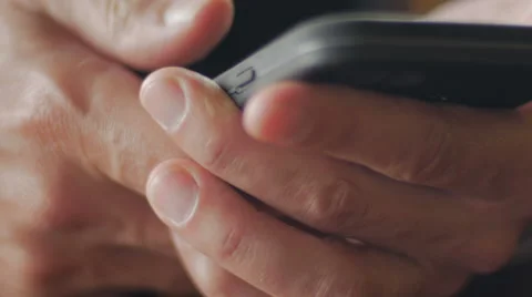 Extreme closeup of mans hands using mobile phone Stock Footage 65338314