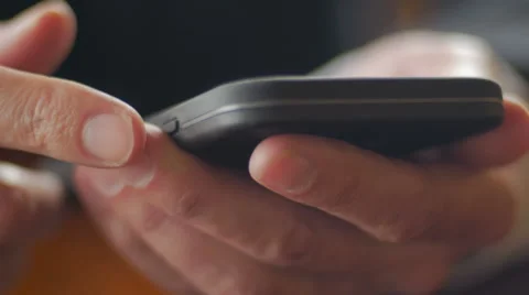 Extreme closeup of mans hands using mobile phone Stock Footage 65338318