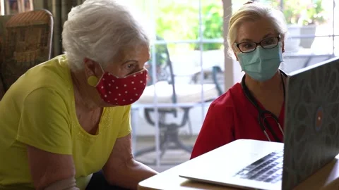 Extreme closeup of nurse talking to an elderly woman looking at computer screen Stock Footage 136426940