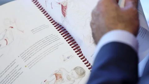 Extreme Closeup On A Page While a Reading Medical Book Searching Treatment  . Stock Footage 145958141