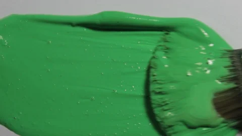 Extreme closeup of a paintbrush applying thick layer of fresh green paint Stock Footage 92327131