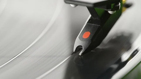 Extreme closeup of record player showing needle on record - black vinyl spinning Stock Footage