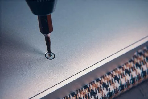 An Extreme CloseUp of a Screwdriver Skillfully Inserting a Screw into a Piece Stock Photos
