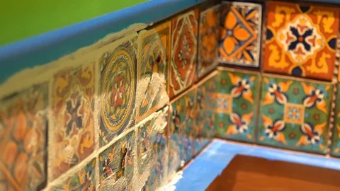 Extreme closeup of a spatula float applying grout to colorful tiles. Stock Footage 101434734