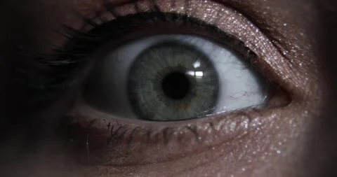 Extreme closeup view of woman's opening beautiful eye with green iris in dark. Stock Footage 147347699