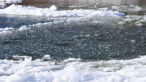 Extreme cold temperatures freezing over river, floating ice down the stream Stock Footage 262001773