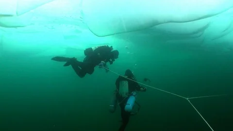 Extreme diving under ice under cold water of lake Baikal. Stock Footage 100379105