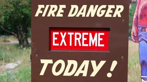 EXTREME Fire Danger Today red and white sign on brown metal board wide Stock Footage 158807127
