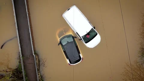 Extreme flooding submerging vehicles in deep muddy water on rural roadway. Heavy Stock Footage 332218389