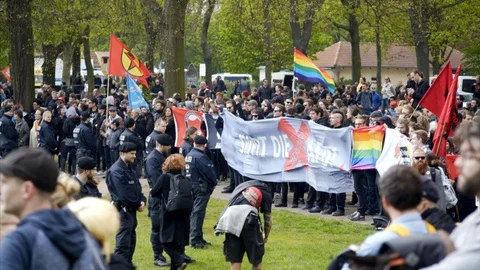 Extreme left Antifa park protest, flags banners, police officer line, Berlin Stock Footage 87456045