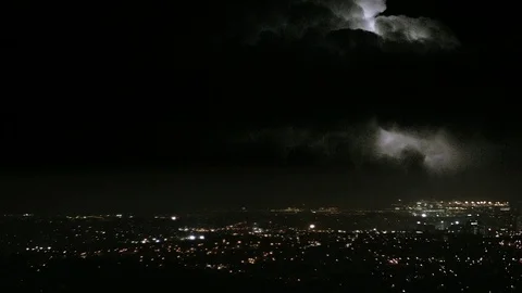 Extreme lightning flashes over a city during large electrical storm. Stock Footage 80657563