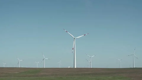 Extreme long shot of wind generators on windmill field with grass Stock Footage 238009768