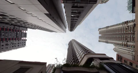 Extreme low angle panning view of narrow towering houses in Hong Kong Stock Footage 309360589