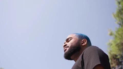 Extreme low angle  portrait of black man head against blue 스톡 동영상 287491297
