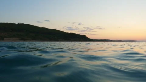 Extreme low angle sea-level view moving forward at sunset Stock Footage 279430641
