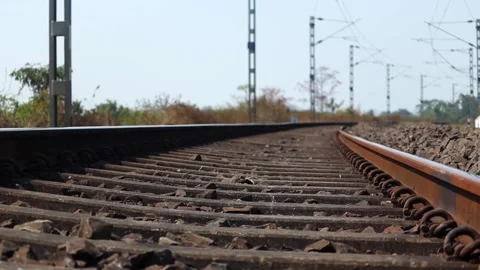 Extreme low angle view of curved railway track with overhead electric lines Stock Footage 330705815