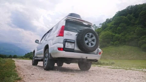 Extreme Low Angle View of SUV Convoy Driving on Mountain Dirt Road Stock Footage 338278175