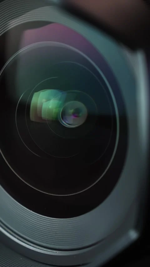 Extreme macro of a camera lens as aperture blades close down, shifting light Stock Footage 332456402