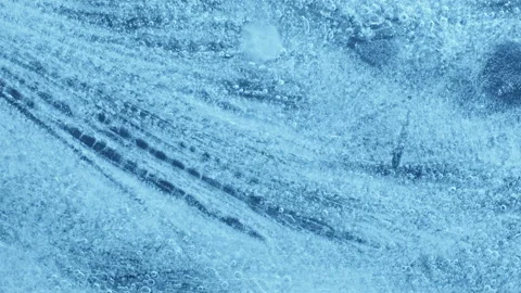 Extreme macro close-up of cracked blue melting ice texture in time lapse Stock Footage 334458376