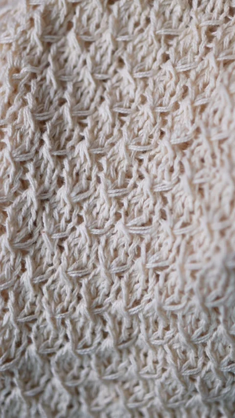 Extreme macro close-up of a cream-colored knitted fabric texture. Stock Footage 329418323