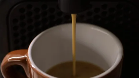 Extreme Macro Close Up Of Espresso coffee Pouring into brown cup. Coffee Machine Stock Footage 122299011