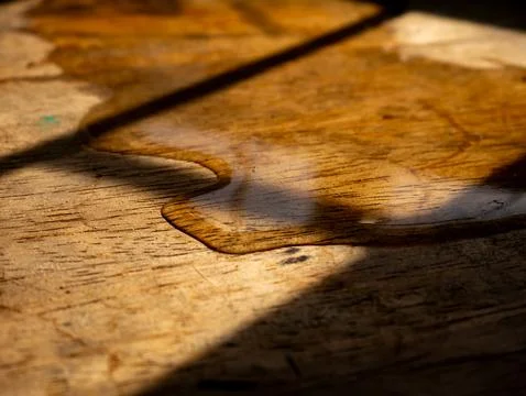 Extreme macro close-up of melted ice water puddle edge on aged rustic woode.. Foto stock