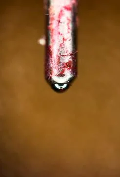 Extreme macro close-up of a red ballpoint pen tip with ink droplet and copy Stock Photos