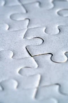 Extreme macro close up of white jigsaw puzzle connection Stock Photos