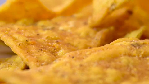 Extreme macro of crispy corn nacho chip surface with dark spices rotating Stock Footage 345610843